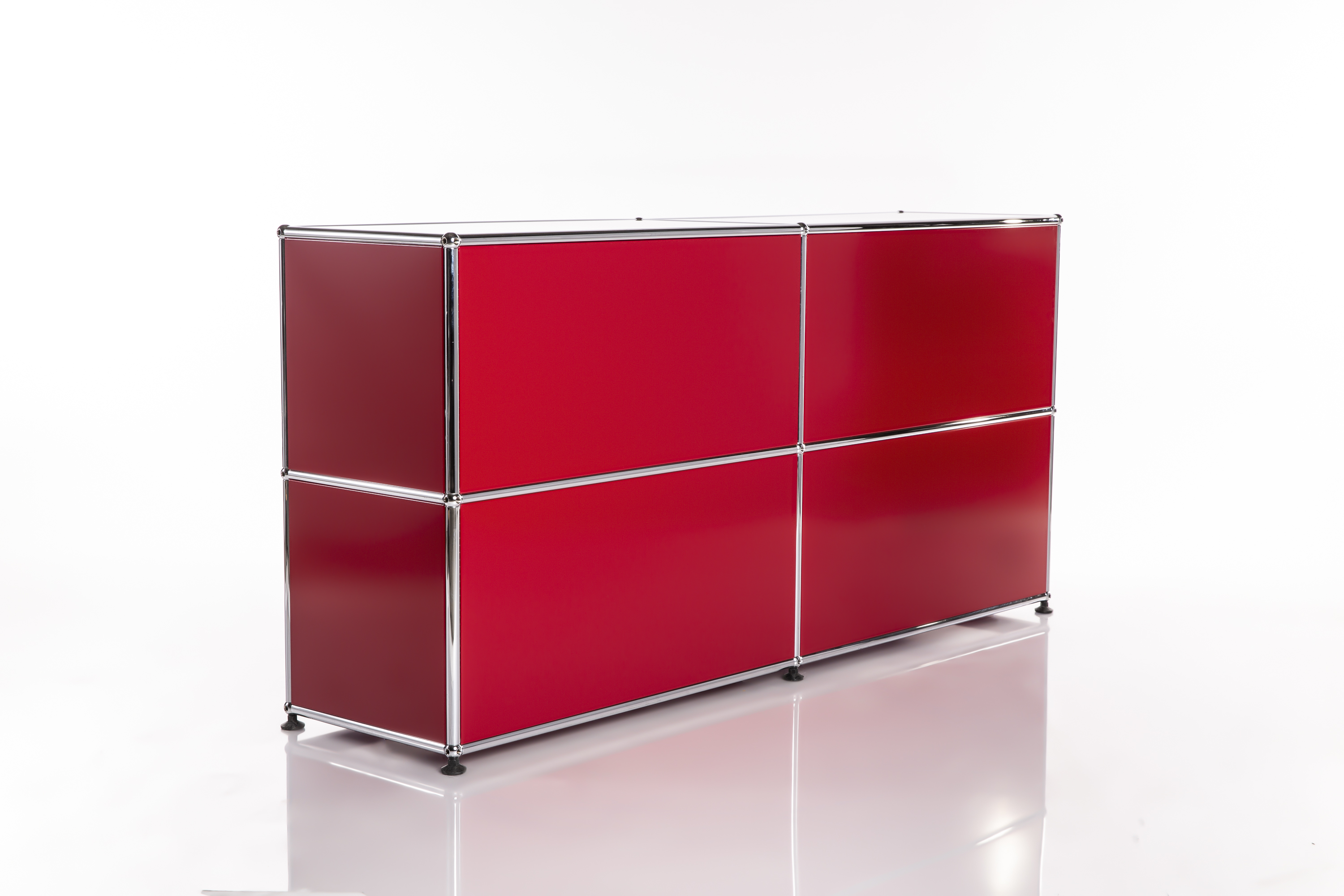 Credenza moderna e modulare in rosso brillante con quattro scomparti quadrati. Incorniciata da tubi cromati lucidi e giunti sferici per un design pulito ed elegante. Su sfondo bianco riflettente.