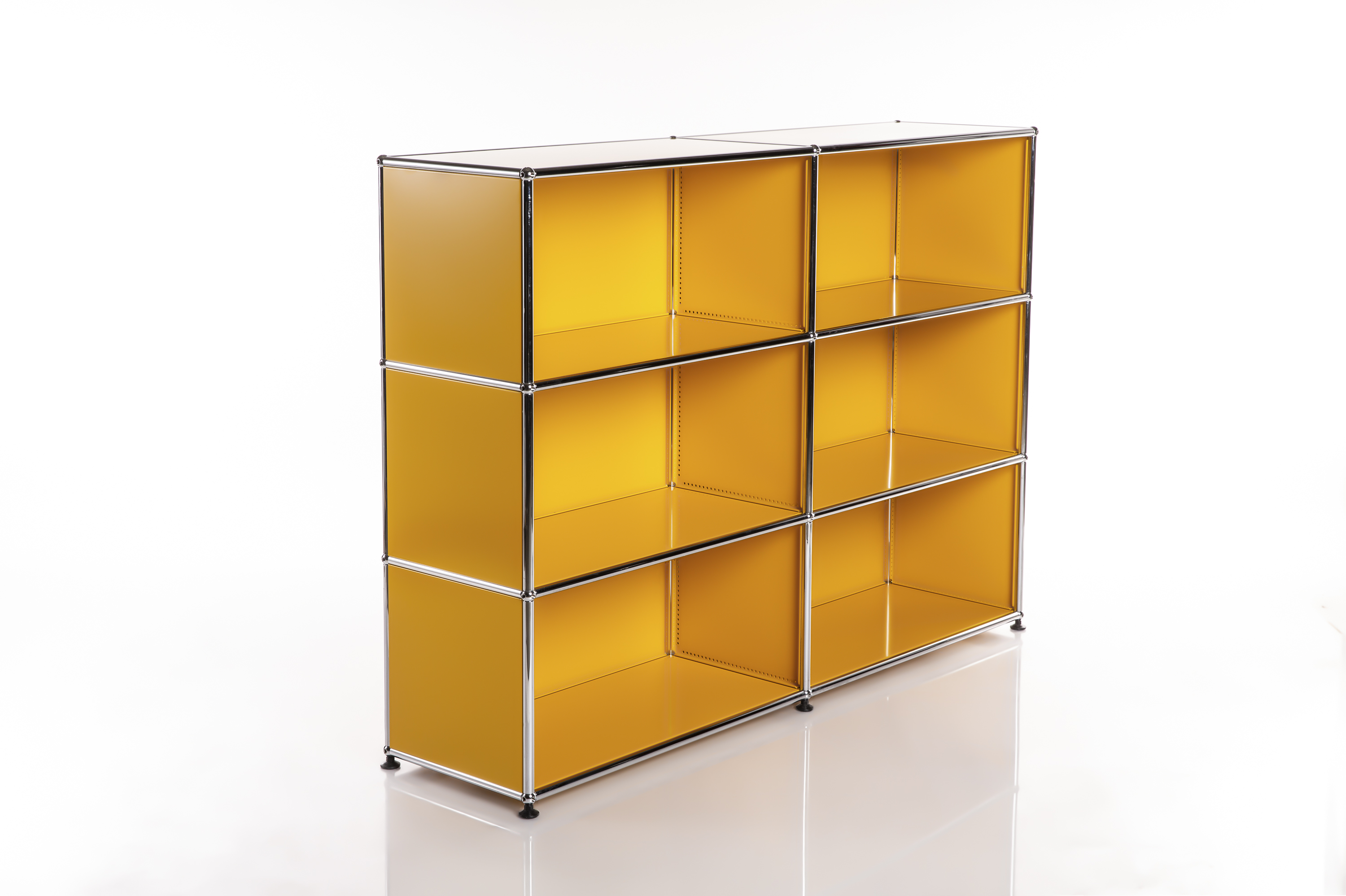 A glossy, modular shelving unit in a vibrant yellow-orange colour with a chrome-plated metal frame, standing on a white, reflective base. The shelving unit consists of nine cube-shaped compartments arranged in a 3x3 grid.