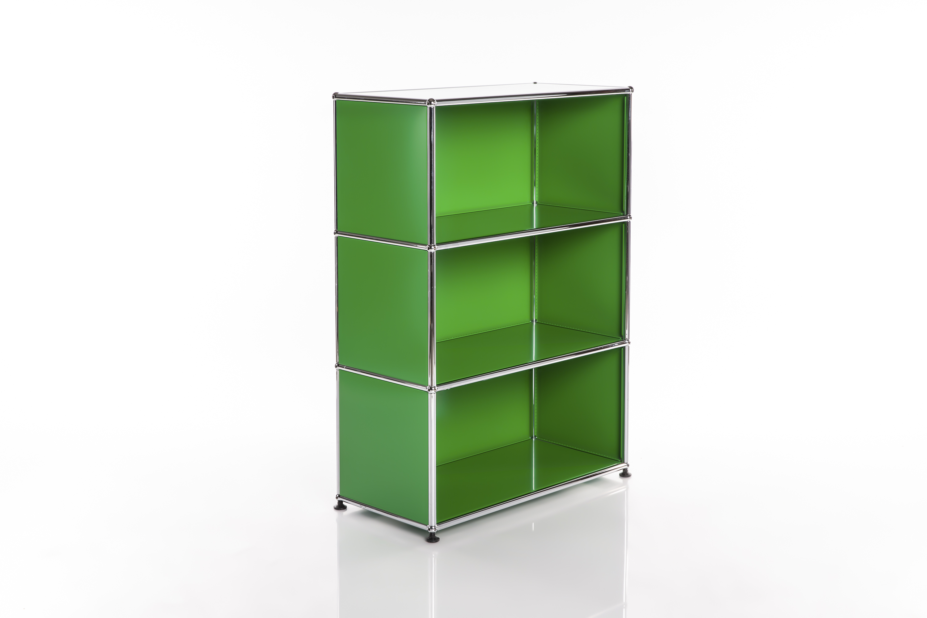 A tall, slender modular shelving unit with three compartments of equal size stacked one on top of the other. The empty green cubes are framed by shiny chrome frames and stand on a white base with a slight mirror-like sheen.