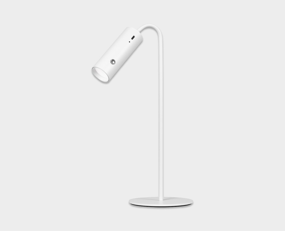 Schlanke, weiße Hansa LED Tischleuchte im minimalistischen Design. Zylindrischer Leuchtenkopf an geschwungenem Arm, der von einem dünnen, vertikalen Ständer am runden Standfuß ausgeht. Mit Bedienknopf und Ladeanzeige.