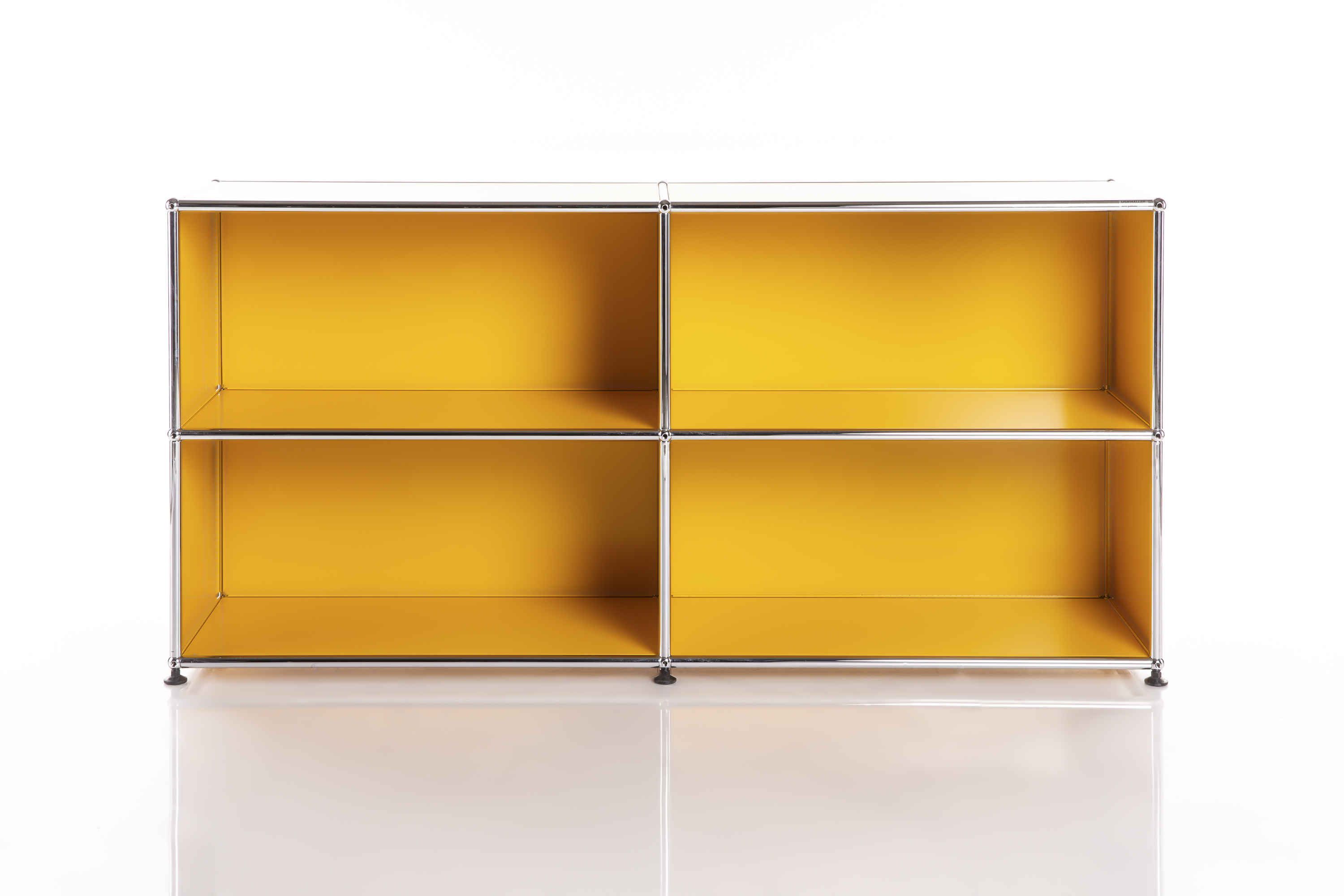 Elegante scaffale modulare con 4 scomparti aperti in configurazione 2x2. Ripiani e laterali giallo brillante, tubi e sfere di collegamento in cromo lucido. Su superficie chiara con sfondo bianco, stile minimalista.