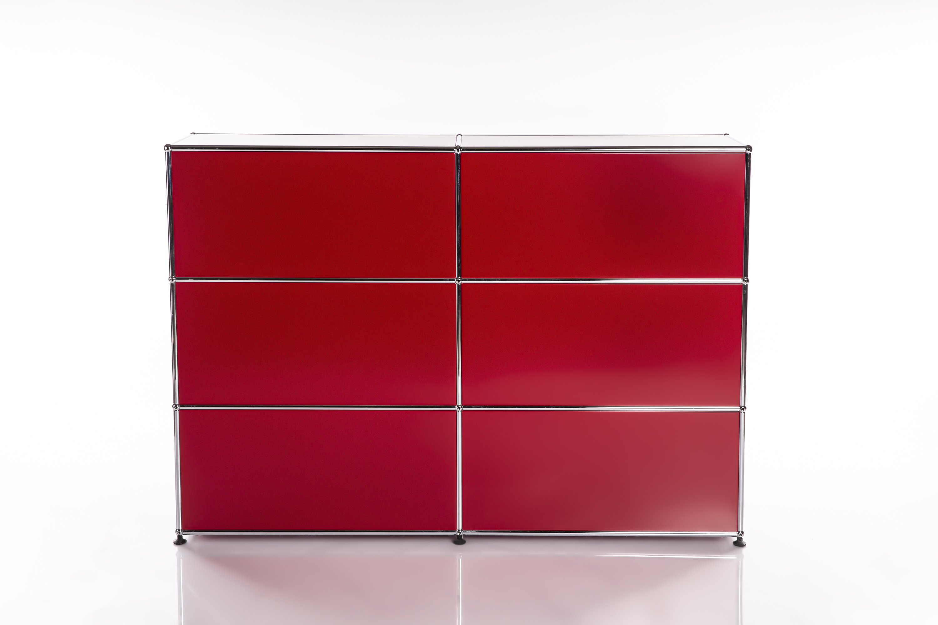 A modern, modular sideboard in bright red with a glossy chrome frame. Six square compartments arranged in three rows and two columns. It stands on a white base with a reflective surface that partially mirrors the unit.