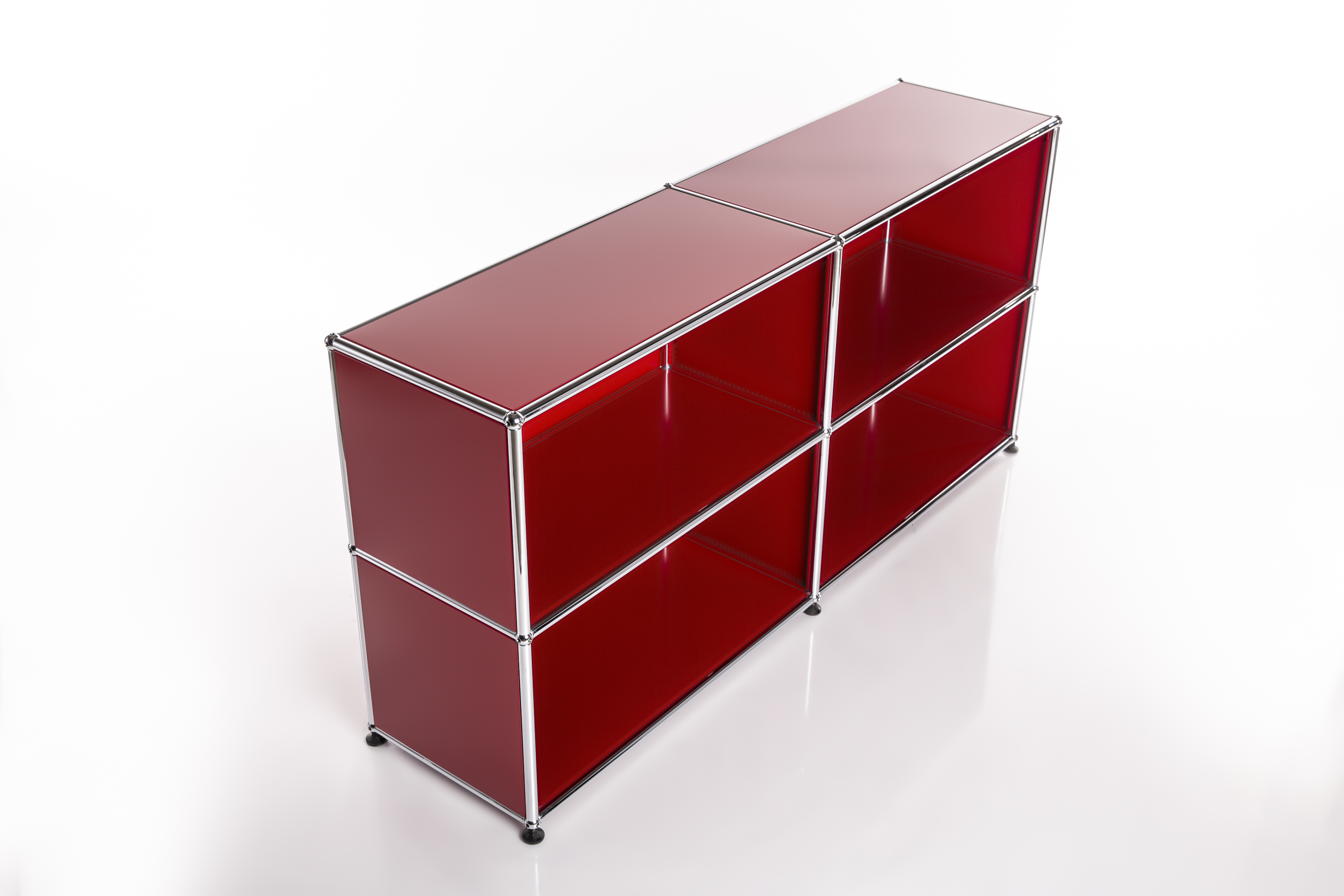 Scaffale moderno e modulare in rosso brillante con telai cromati lucidi. Due moduli orizzontali, ciascuno con due ripiani aperti. Pannelli rossi lisci riflettono la luce, tubi cromati su sfondo chiaro.