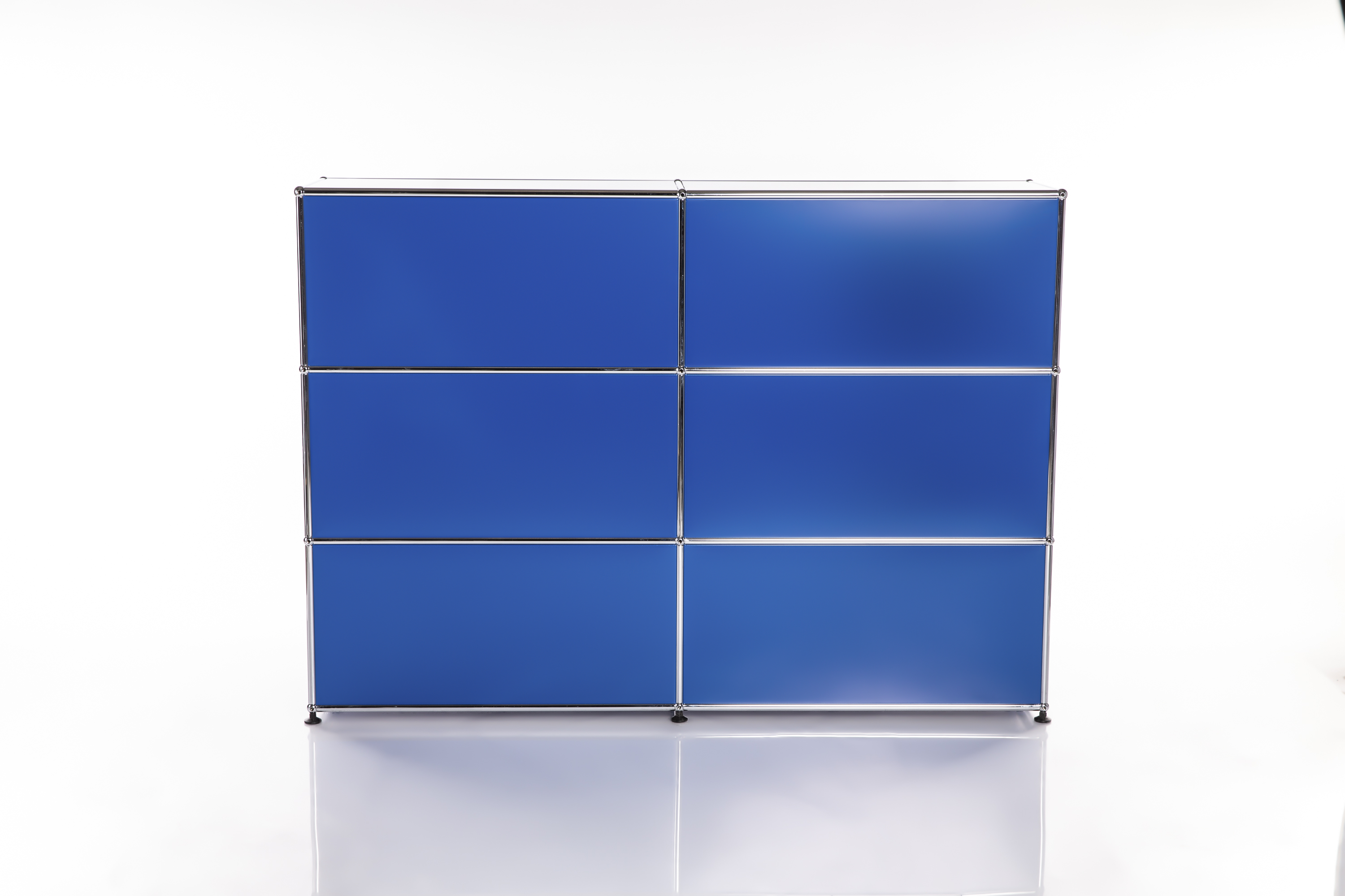 Une étagère moderne et modulaire d'un bleu vif, dotée d'un cadre chromé brillant et composée de six compartiments. Elle repose sur un socle blanc réfléchissant devant un fond clair et a été photographiée en studio.