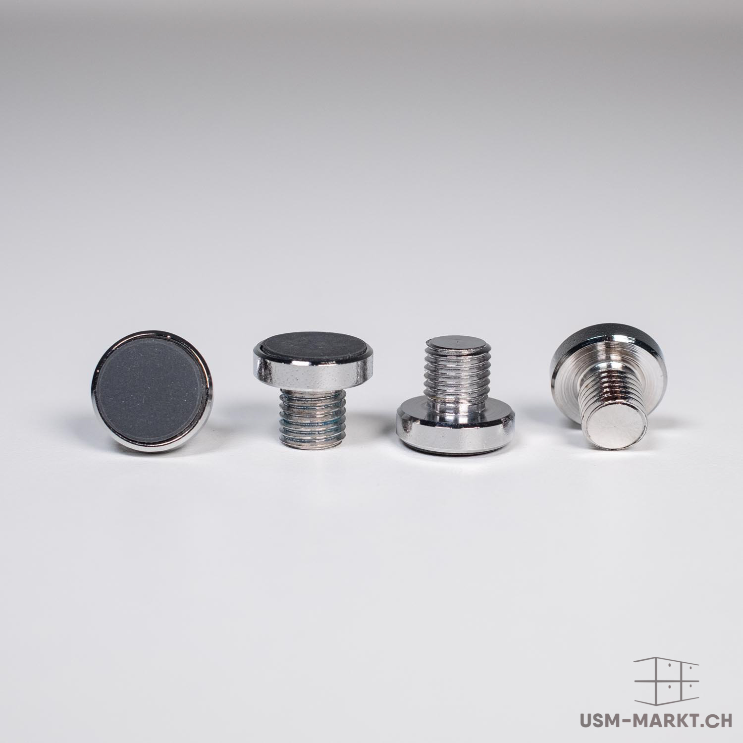 Four shiny, silver-coloured threaded magnets on a light grey background. On the left, a round magnet with a dark surface; next to it, a magnet head with a short thread. On the right, two views of the threaded parts, the last one from the side.