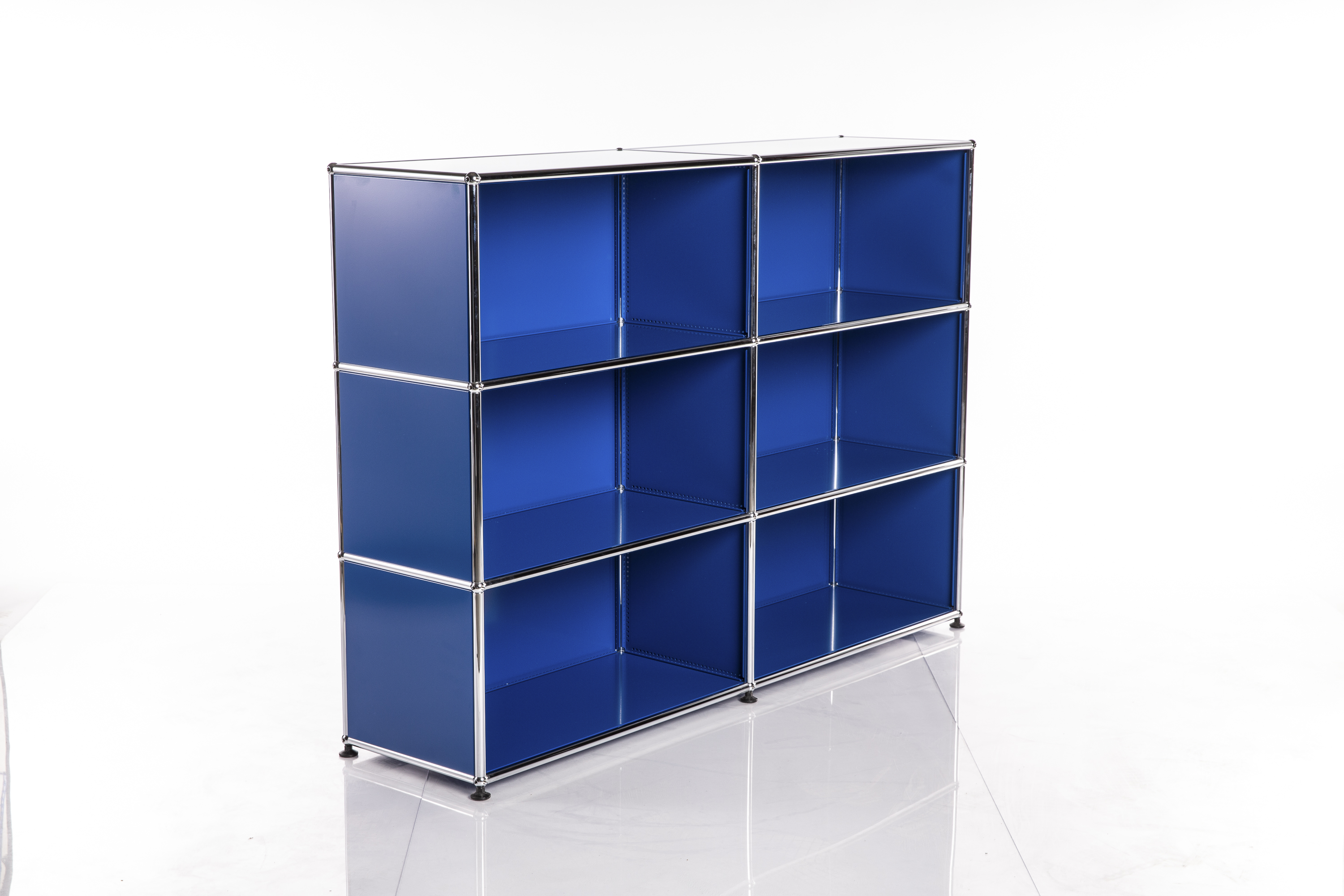Étagère moderne et minimaliste d'un bleu roi éclatant, dotée de neuf compartiments carrés. Des montants métalliques argentés brillants et des raccords ronds encadrent les panneaux bleus. Repose sur de petits pieds noirs.