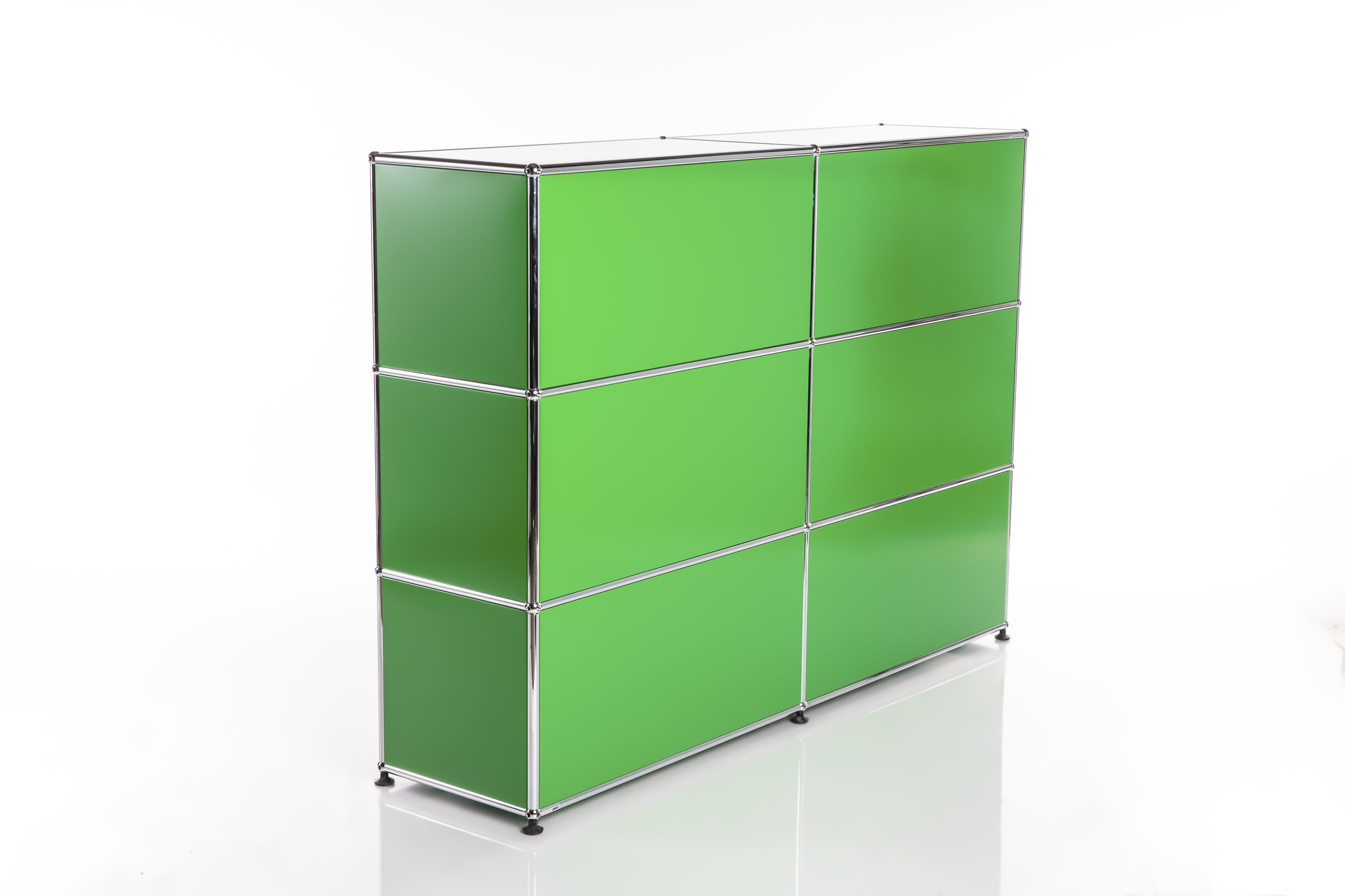 A modern modular shelving system in bright green with six square compartments (2 columns, 3 rows), connected by shiny chrome tubes and balls. It stands on small dark feet and reflects slightly against a white background.