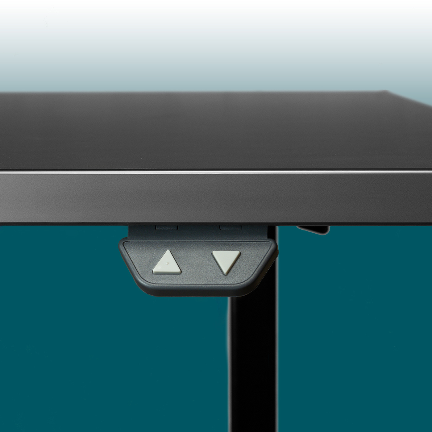A close-up view of the underside of a dark grey tabletop on a height-adjustable desk. A control panel is attached, featuring two light grey triangular buttons (up arrow, down arrow). To the right is the black leg.