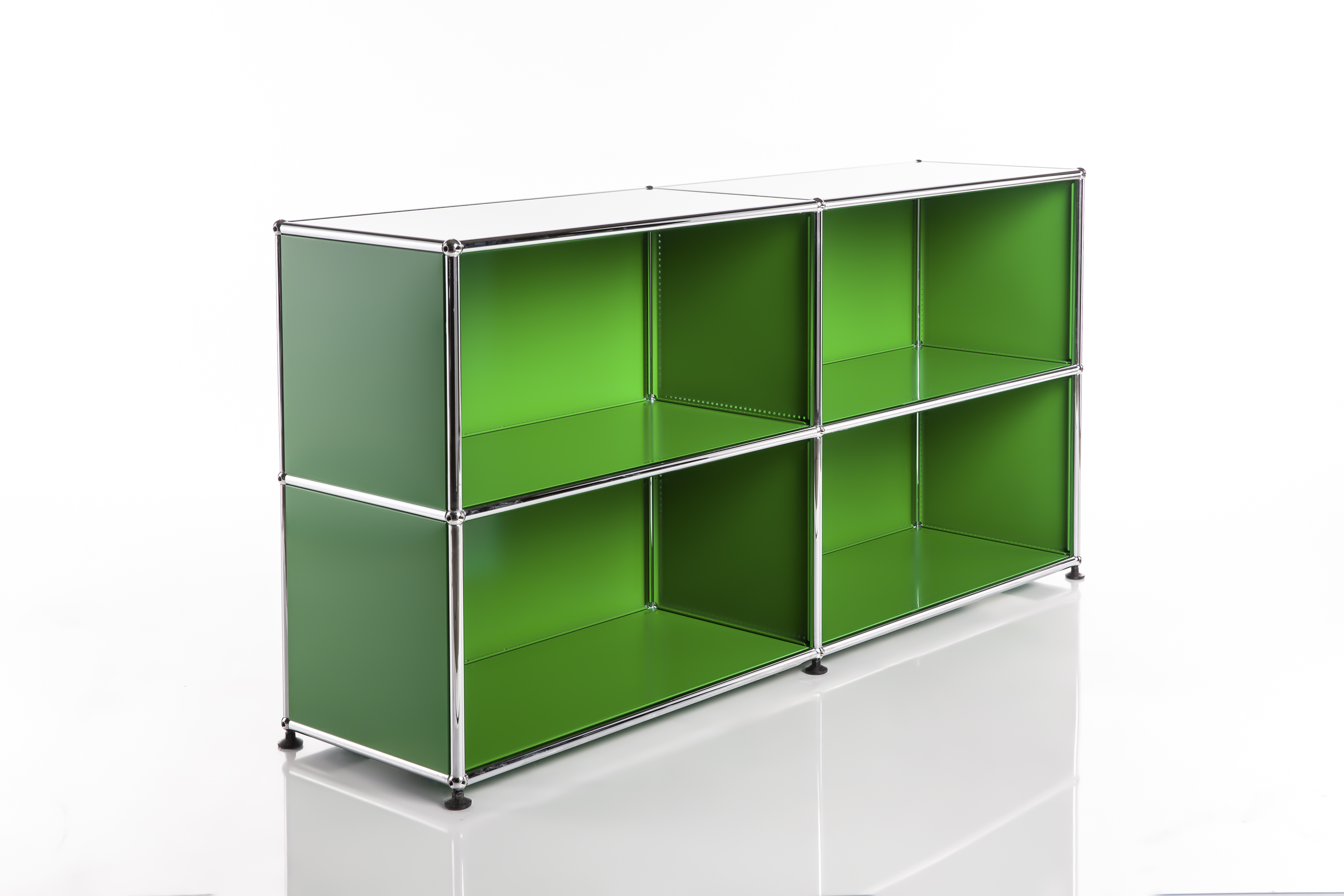 A modern, modular shelving unit comprising two side-by-side sections, each with two open compartments. Bright green, with a polished chrome frame featuring ball joints. Resting on small black feet, with a slight sheen on the white surfaces.