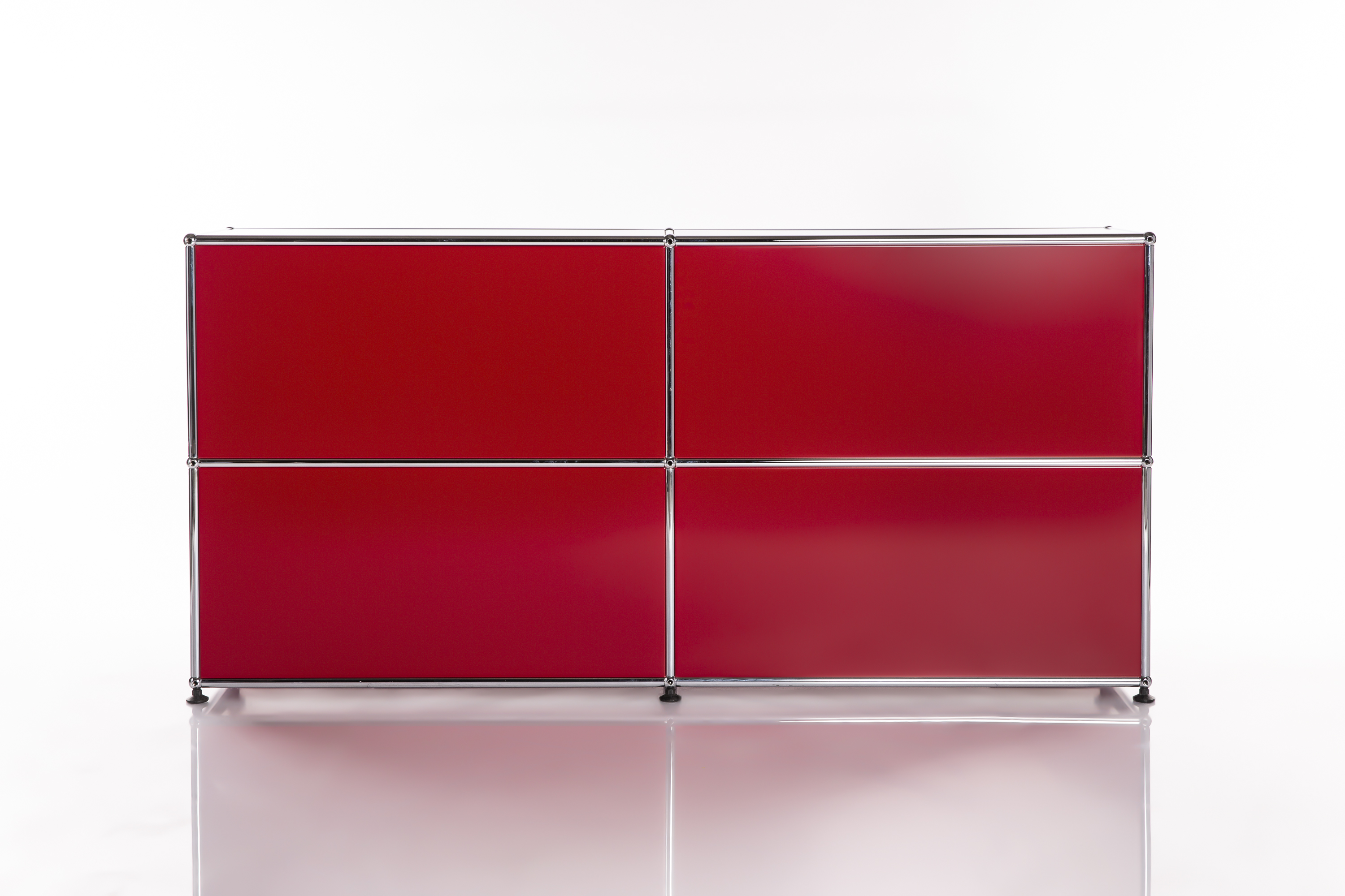 Mobili modulari minimalisti e moderni con quattro pannelli rettangolari di un rosso brillante disposti in una griglia 2x2. Telaio cromato sottile per un look pulito e contemporaneo. Su superficie bianca riflettente con un sottile effetto specchio.