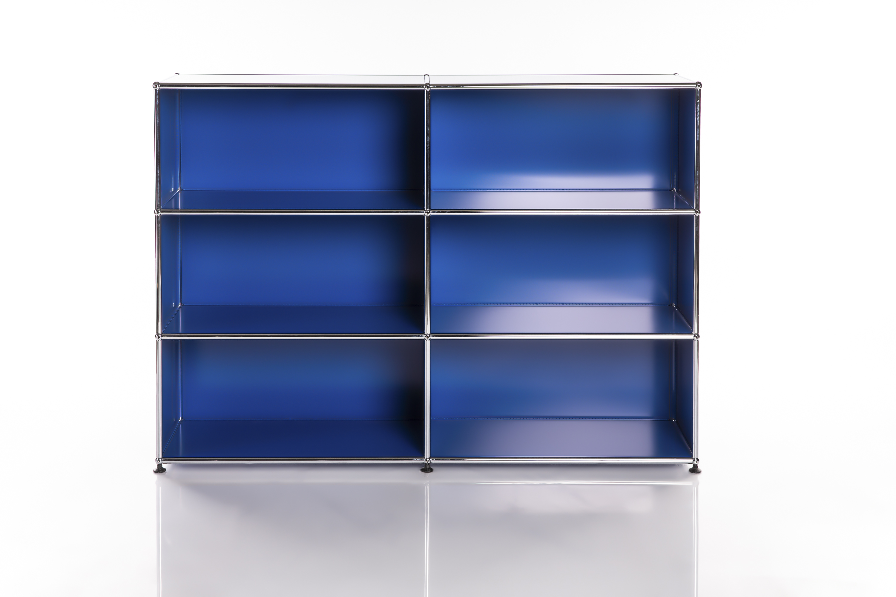 A modern, modular shelving unit in vibrant royal blue with six open compartments (3 rows, 2 columns). A sleek, polished metal frame accentuates the blue surfaces. Set on dark legs against a white background.