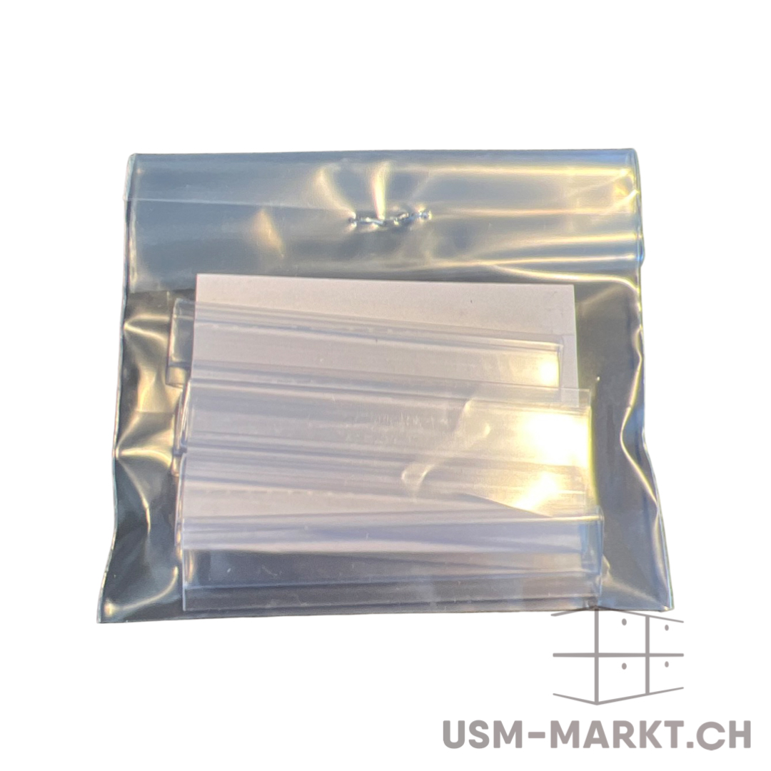 Transparente Plastiktüte mit mehreren durchsichtigen, schmalen Kunststoffstreifen, übereinanderliegend. Dahinter ist ein weißes Stück Papier oder Karton sichtbar. Oben versiegelt, Inhalte ordentlich gestapelt und bereit zur Verwendung.
